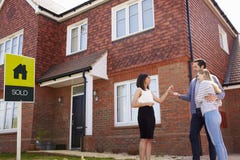 Young Couple Collecting Keys To New Home From Realtor royalty free stock photos Young Couple Collecting Keys To New Home From Realtor royalty free stock photos