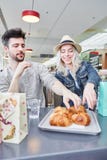 Young couple is eating croissants in bistro stock image Young couple is eating croissants in bistro stock image