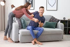 Young couple fighting for joystick while playing video games Stock Image Young couple fighting for joystick while playing video games Stock Image