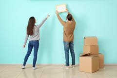 Young couple hanging picture on wall in their new house royalty free stock photography Young couple hanging picture on wall in their new house royalty free stock photography