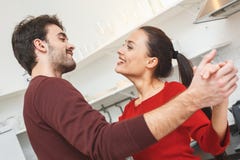 Young couple having romantic evening at home in the kitchen dancing close-up. Young men and women having romantic evening indoors in the kitchen dancing looking stock photography Young couple having romantic evening at home in the kitchen dancing close-up. Young men and women having romantic evening indoors in the kitchen dancing looking stock photography