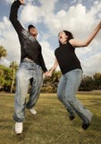 Young Couple Jumping In The Air Stock Image