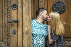 Young couple kissing while standing next to an ancient doors. Love Royalty Free Stock Images Young couple kissing while standing next to an ancient doors. Love Royalty Free Stock Images