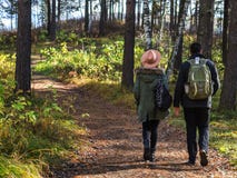 Young couple in love holding hands and walking through a park on a sunny autumn day. royalty free stock photos Young couple in love holding hands and walking through a park on a sunny autumn day. royalty free stock photos