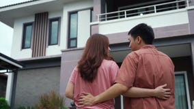 Couple standing outside and looking their house