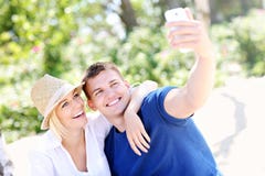 Young couple taking a picture of themselves at the beach Royalty Free Stock Photography Young couple taking a picture of themselves at the beach Royalty Free Stock Photography
