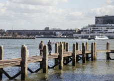 Young couple tourists looking and pointing to Rotterdam city harbour, future architecture concept, industrial lifestyle Stock Images Young couple tourists looking and pointing to Rotterdam city harbour, future architecture concept, industrial lifestyle Stock Images
