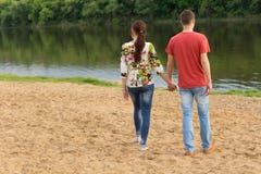 Young couple walking towards the edge of the lake royalty free stock photos Young couple walking towards the edge of the lake royalty free stock photos