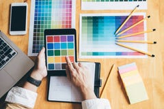 Young creative Graphic designer using graphics tablet to choosing Color swatch samples chart for selection coloring with work too royalty free stock image Young creative Graphic designer using graphics tablet to choosing Color swatch samples chart for selection coloring with work too royalty free stock image