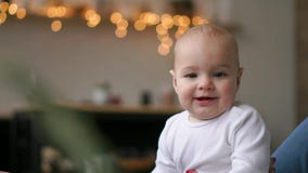 Young cute girl playing with her son on the bed. A young mother is playing with a baby on the bed. stock video footage Young cute girl playing with her son on the bed. A young mother is playing with a baby on the bed. stock video footage