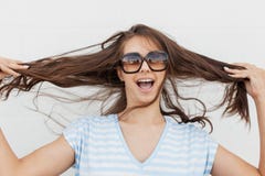 A young cute slim dark-haired girl,wearing casual clothes,is looking at the camera and holding her hair . stock photography A young cute slim dark-haired girl,wearing casual clothes,is looking at the camera and holding her hair . stock photography