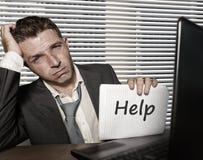 Young desperate and stressed business man working overwhelmed at office computer desk feeling helpless and overworked holding royalty free stock image Young desperate and stressed business man working overwhelmed at office computer desk feeling helpless and overworked holding royalty free stock image