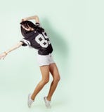 Young energetic sports active girl dancing in the Studio on a light background in t-shirt and shorts stock photography Young energetic sports active girl dancing in the Studio on a light background in t-shirt and shorts stock photography