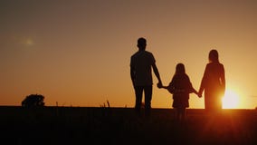 Young family with a child admiring the sunset in the field, holding hands royalty free stock photo Young family with a child admiring the sunset in the field, holding hands royalty free stock photo