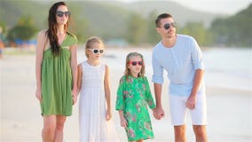 Family of four on a tropical beach stock video footage Family of four on a tropical beach stock video footage