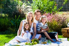 Young family having picnic in a park Stock Photos Young family having picnic in a park Stock Photos