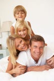 Young Family Relaxing In Bed Together stock image Young Family Relaxing In Bed Together stock image