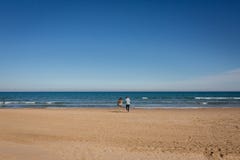 Young family walking in empty beach Gandia, Spain royalty free stock image Young family walking in empty beach Gandia, Spain royalty free stock image