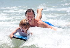 Young father and son learning to surf