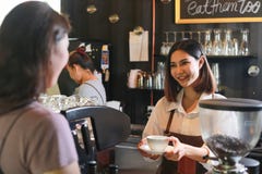 Young female barista serving coffee to customer in cafe. royalty free stock image Young female barista serving coffee to customer in cafe. royalty free stock image