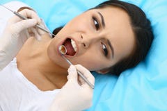 Young female patient visiting dentist office.Beautiful woman feeling fear and pain during doctor working at teeth royalty free stock photo Young female patient visiting dentist office.Beautiful woman feeling fear and pain during doctor working at teeth royalty free stock photo