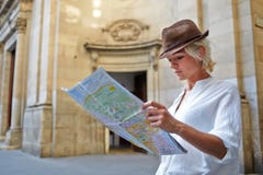 Young female student with trendy look examines atlas during traveling abroad in summer vacation stock photo Young female student with trendy look examines atlas during traveling abroad in summer vacation stock photo
