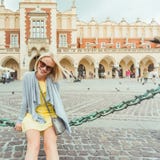 Young female tourist sitting near Cloth Hall in the old city center of Krakow royalty free stock images Young female tourist sitting near Cloth Hall in the old city center of Krakow royalty free stock images