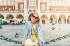 Young female tourist sitting near Cloth Hall in the old city center of Krakow stock image Young female tourist sitting near Cloth Hall in the old city center of Krakow stock image