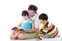 Young female with two little asian children reading a book