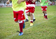 Young football players run in red and white shirts stock photography Young football players run in red and white shirts stock photography