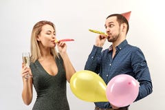 Young funny couple in office clothes celebrate a birthday or corporate event, organize a party with champagne, balloons stock photography Young funny couple in office clothes celebrate a birthday or corporate event, organize a party with champagne, balloons stock photography