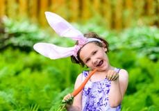 Young Girl in Bunny Ears Eating a Carrot royalty free stock photo Young Girl in Bunny Ears Eating a Carrot royalty free stock photo