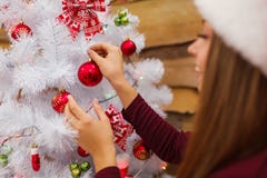 A young girl decorates a Christmas tree with toys. Christmas atmosphere. Indoors. royalty free stock photography A young girl decorates a Christmas tree with toys. Christmas atmosphere. Indoors. royalty free stock photography
