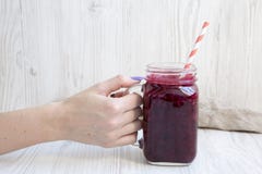 Young girl holding a jar with smoothie over white wooden background. stock images Young girl holding a jar with smoothie over white wooden background. stock images