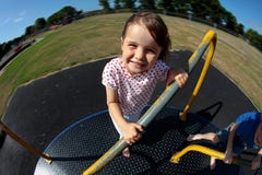 Young girl playing on roundabout in sunny park royalty free stock photo Young girl playing on roundabout in sunny park royalty free stock photo