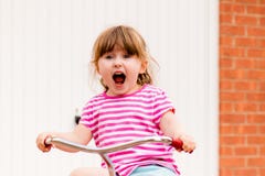 A young girl shouting while riding a bicycle royalty free stock photo A young girl shouting while riding a bicycle royalty free stock photo