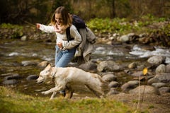 Young girl trains and plays with puppy golden retriever in the wild, next to a river. royalty free stock photo Young girl trains and plays with puppy golden retriever in the wild, next to a river. royalty free stock photo