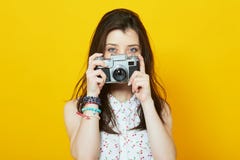 Young girl with vintage camera over yellow background stock images Young girl with vintage camera over yellow background stock images