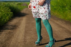 Young girl wearing floral dress. Poppy in her hand, alley in the field Stock Photo Young girl wearing floral dress. Poppy in her hand, alley in the field Stock Photo