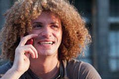Young guy with curly hair talk on cellphone Stock Photography Young guy with curly hair talk on cellphone Stock Photography