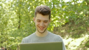Young guy working with laptop and laughing
