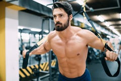 Young handsome man doing exercises in gym stock photo Young handsome man doing exercises in gym stock photo