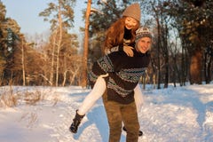 A young handsome man of European appearance and a young Asian girl in a park on the nature in winter. A royalty free stock images A young handsome man of European appearance and a young Asian girl in a park on the nature in winter. A royalty free stock images