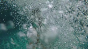 Young handsome man jumping into swimming pool holds go pro camera during amazing sunset and swims underwater between stock video Young handsome man jumping into swimming pool holds go pro camera during amazing sunset and swims underwater between stock video