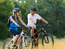 Young Happy Couple Riding Mountain Bikes Outdoor stock photo Young Happy Couple Riding Mountain Bikes Outdoor stock photo