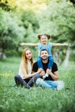 Young happy family of three having fun together outdoor. Pretty little daughter on her father piggyback smiling and have fun. royalty free stock images Young happy family of three having fun together outdoor. Pretty little daughter on her father piggyback smiling and have fun. royalty free stock images