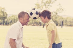 Young happy father and excited 7 or 8 years old son playing together soccer football on city park garden posing sweet and loving h royalty free stock images Young happy father and excited 7 or 8 years old son playing together soccer football on city park garden posing sweet and loving h royalty free stock images