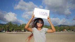 Young Happy Girl with Go Vegan Healthy Diet Propaganda Sign on a Beach. Koh Phangan, Thailand. HD Slowmotion.