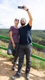 Young Happy hiker couple taking a selfie in the mountain with a smart phone royalty free stock photo Young Happy hiker couple taking a selfie in the mountain with a smart phone royalty free stock photo