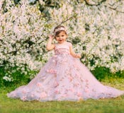 Young happy little girl fairy princess. Happy child face is smiling. Luxurious fluffy long dress for children, pink